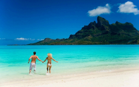 together in paradise - summer, beach, ocean, isle, vacation, couple, woman, paradise, tropic, tropical, mountains, water, hills, sun, sky, skyphoenixx1, holiday, island, clouds, people, sea, waves, sunshine, man