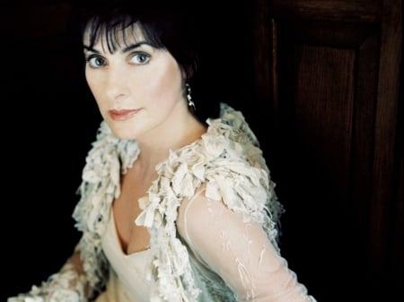 Unique Enya - dark hair, white dress, singer, ruffles on sleeves and shoulders, celtic new age