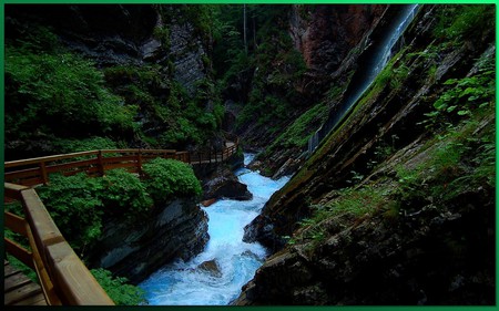 Track along the mountain river - waterfall, swirling water, mountains, walkway bridge, rocks