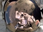 Astronaut Stephen Robinson repairs damage to Space Shuttle