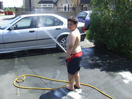 He's a good boy rinsing down his Dads car. - car wash, water shortage who cares