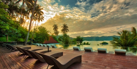 Orient Exotic - clouds, relax, swimming pool, hills, beautiful, chairs, wooden deck, sea, travel, vacations, resort, sunset, tropical, palm trees, sky