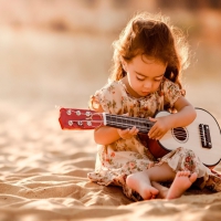 Cute guitarist on sand