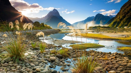 Mountain Sunset - new zealand, sunset, mountains, river, beautiful, clouds, milford sound, stones, flowers, grass