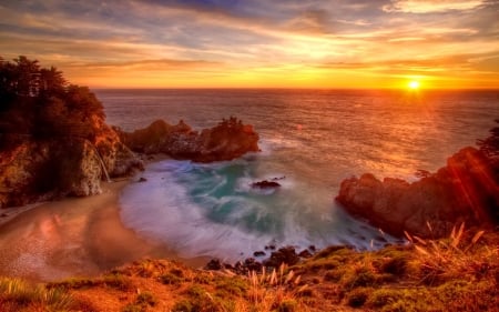 McWay falls at sunset - seaside, sky, falls, sun, sunset, waterfall, coast, rocks, view, fiery, beautiful, sea, wildflowers