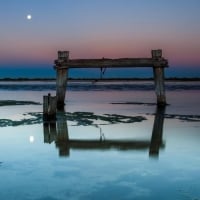 moon over broken seashore pier