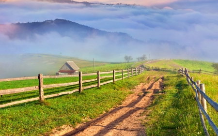 misty countryside landscape - fences, fields, mist, road, cabins