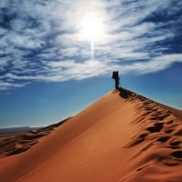 traveler atop a sand dune