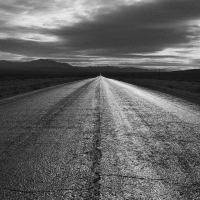 asphalt road through desert in monochrome