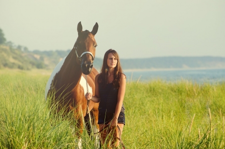 Afternoon Walk - trees, female, water, tall grass, grass, ocean, horse, mountain, cowgirl, lady, woman, field, brunette