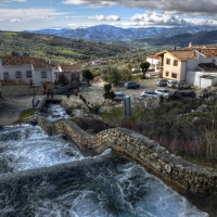 cascading waterfall through a town hdr