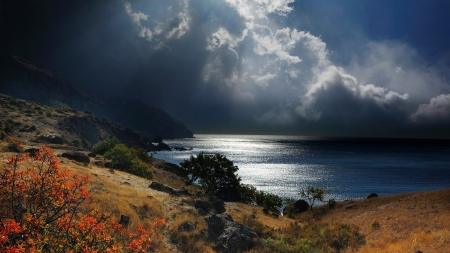 sunlight thru clouds over mountainous seashore - sunshine, clouds, shore, mountains, sea, grass