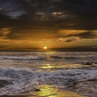 waves crashing on beach at sunrise