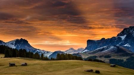 mountain meadow under orange sunset - sunset, cabins, grass, meadow, orange, mountains