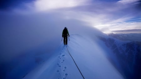 climber reaching summit in a snow storm