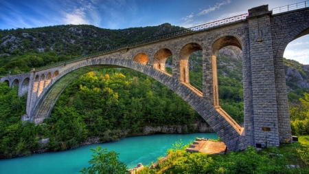 stone arch bridge over turquoise river hdr