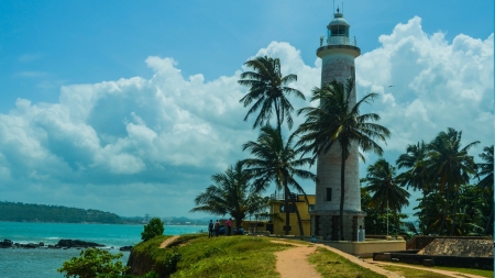 clouds over a lighthouse on a tropical point - clouds, trees, tropical, lighthouse, pont, bay