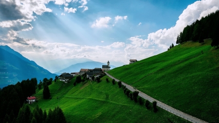 road to a mountainside village - village, road, slope, grass, mountains, sky