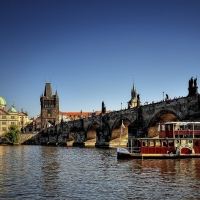 tour boat gliding under a bridge in prague