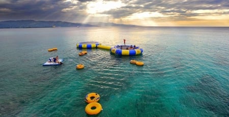 Montego Bay - clouds, sunrays, people, sea, trampolines, jamaica