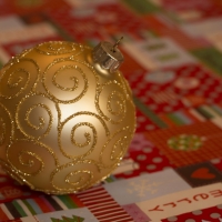 Golden Bauble on Christmas Wrapping Paper