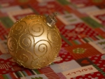 Golden Bauble on Christmas Wrapping Paper