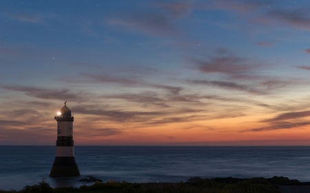 Lighthouse  at Sunset - clouds, sunset, nature, lighthouse, waves, rocks, sky