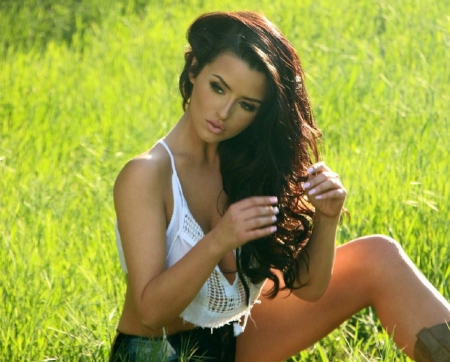 Abigail Ratchford - denim shorts, playing with hair, lace top, sitting in field, cowboy boots, brunette