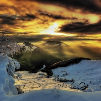 Clouds and Sunbeams over Snowy Winter Mountains