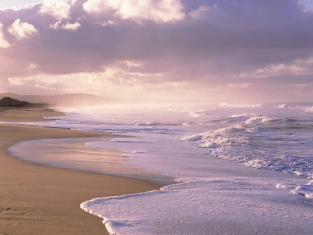 Beach and Ocean Meet Under the cloudy Sky