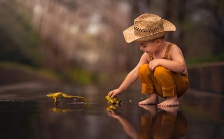 Little boy playing with yellow frogs - hat, boy, cowboy, yellow, little, copil, child, frog