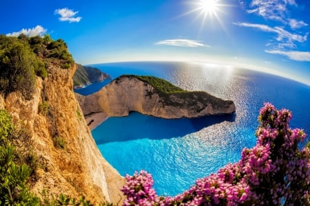 Navagio bay - summer, Greece, reflection, Zakynthos, view, sky, sun, Navagio, sunlight, beautiful, sea, sunshine, wildflowers, glow, rays, rocks, bay