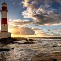 Cloudy Sunset over Rocky Coast Lighthouse