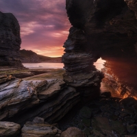 Sunset Beams through Rocky Sea Arch