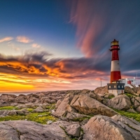 Lighthouse atop Rocky Landscape at Sundown