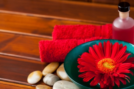 Spa concept - oil, towel, daisy, stones