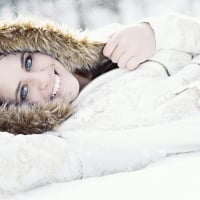 Woman With Blue Eyes Lying In The Snow