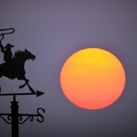 Big sunset behind wind vane