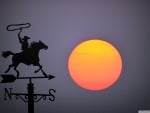 Big sunset behind wind vane