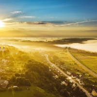 Aerial View of Sunbeams over Foggy Landscape