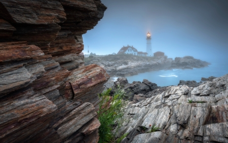 Lighthouse on Rocky Landscape in Fog