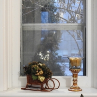 Candle And Sleigh On A Window Sill