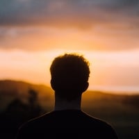 Dark silhouette of man looking at dreary morning sky