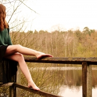 Girl sitting on the railing of the river