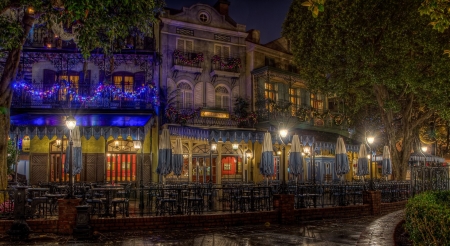 Cafe in New Orleans - orleans, sign, bulidings, chairs, road, garland, town, umbrella, table, cafe, tree, lights