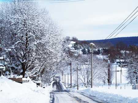 Winter Road - sky, building, rust, trees, countryside, leaf, black, road, white, church, cloud, blue, snow, green, flowers