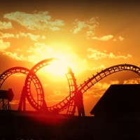 Sunset pierces through amusement park roller coaster during golden hour