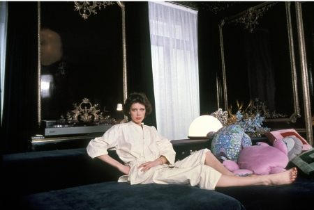 Sylvia Kristel - cushions, window, black reflective walls, jewelry, laying on bed, brunette, white robe