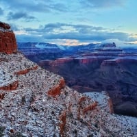 Snowy view of O'Neil Butte in the foreground and Zoroaster Temple in the background at sunrise in the Grand Canyon, Arizona