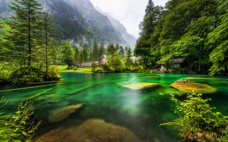 Lake in Swiss Alps - house, trees, water, mountains, rocks, sky